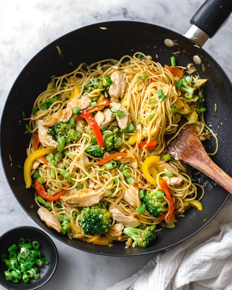 Chicken Lo Mein with Vegetables and Sesame-Ginger Sauce Recipe 5 A black wok filled with stir-fried noodles is shown, containing multiple layers: the bottom layer is light yellow spaghetti noodles, mixed with bright green broccoli florets scattered evenly. On top of the noodles, there are thin slices of white cooked chicken pieces, mixed with strips of red and yellow bell peppers. The dish is garnished with small green onion slices spread across the noodles and vegetables. A wooden spatula rests inside the wok, stirring the ingredients gently. The wok sits on a white marbled surface, with a small black bowl of chopped green onions nearby. A white cloth is partially visible near the bottom right corner. photo taken with an iphone --ar 4:5 --v 7