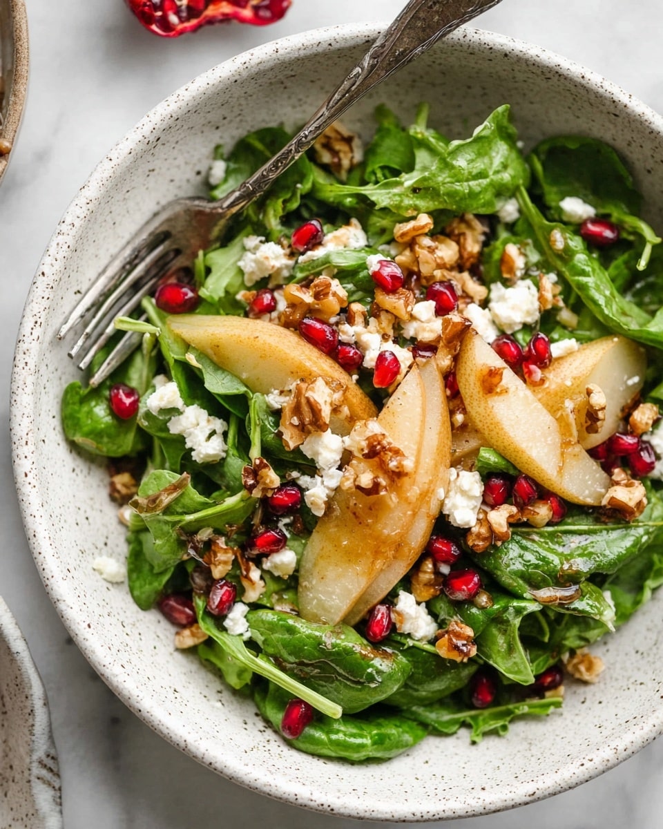 The dish is a fresh salad in a white speckled bowl set on a white marbled surface. The base is made of bright green spinach leaves with a mix of fresh arugula, layered thickly. On top, thin yellow slices of pear are scattered, along with small, juicy red pomegranate seeds. Crumbled white goat cheese pieces are sprinkled generously, mixed with chopped light brown walnuts adding a crunchy texture. A silver fork rests in the bowl, partially covered by the salad, enhancing the fresh and colorful presentation. Photo taken with an iphone --ar 4:5 --v 7