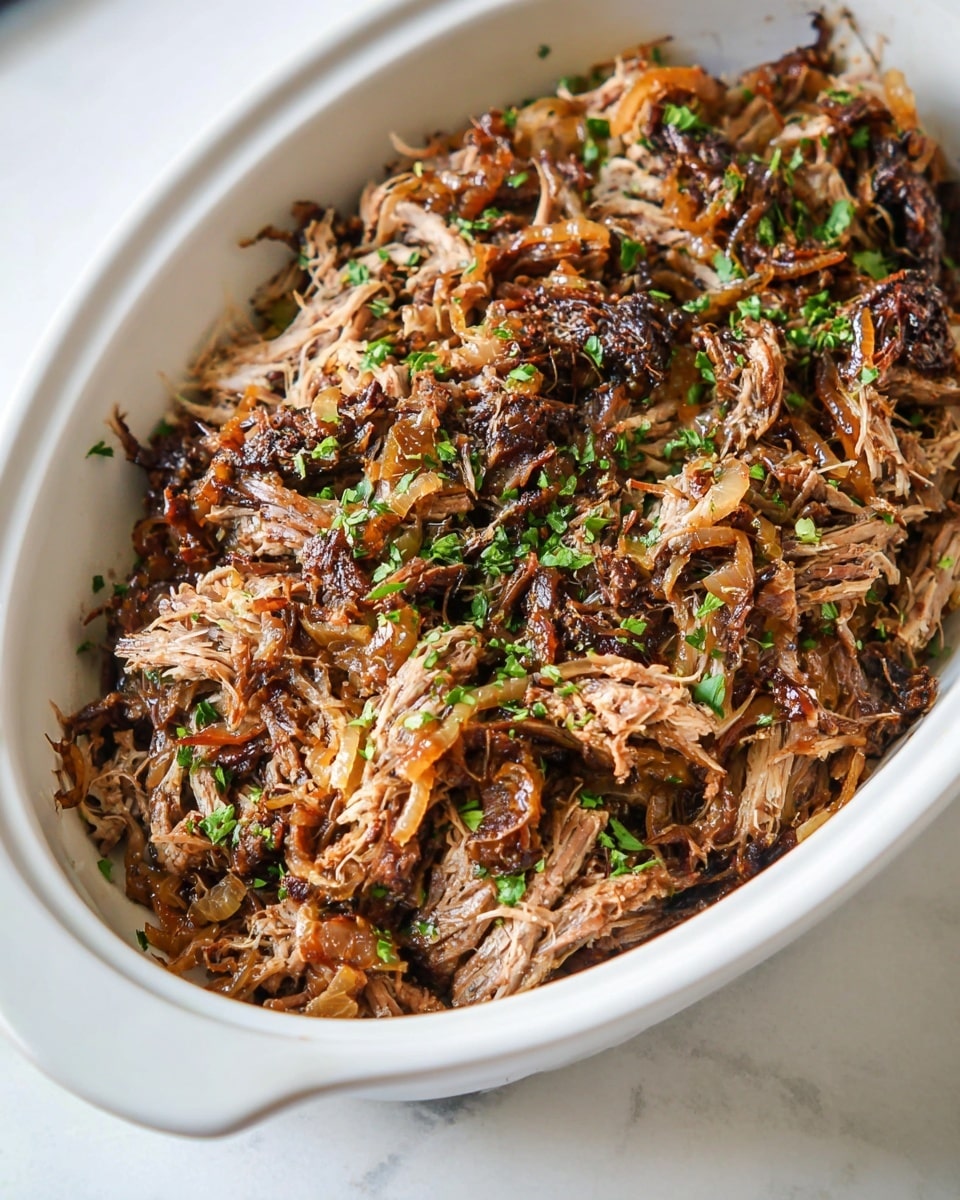 The image shows a white oval dish filled with shredded cooked meat that has a brown color with darker crispy edges. Small bits of browned onions are mixed in with the meat, adding some orange and light brown tones. The top of the dish is sprinkled with small pieces of fresh green herbs for a pop of color. The dish is set on a white marbled surface. Photo taken with an iphone --ar 4:5 --v 7