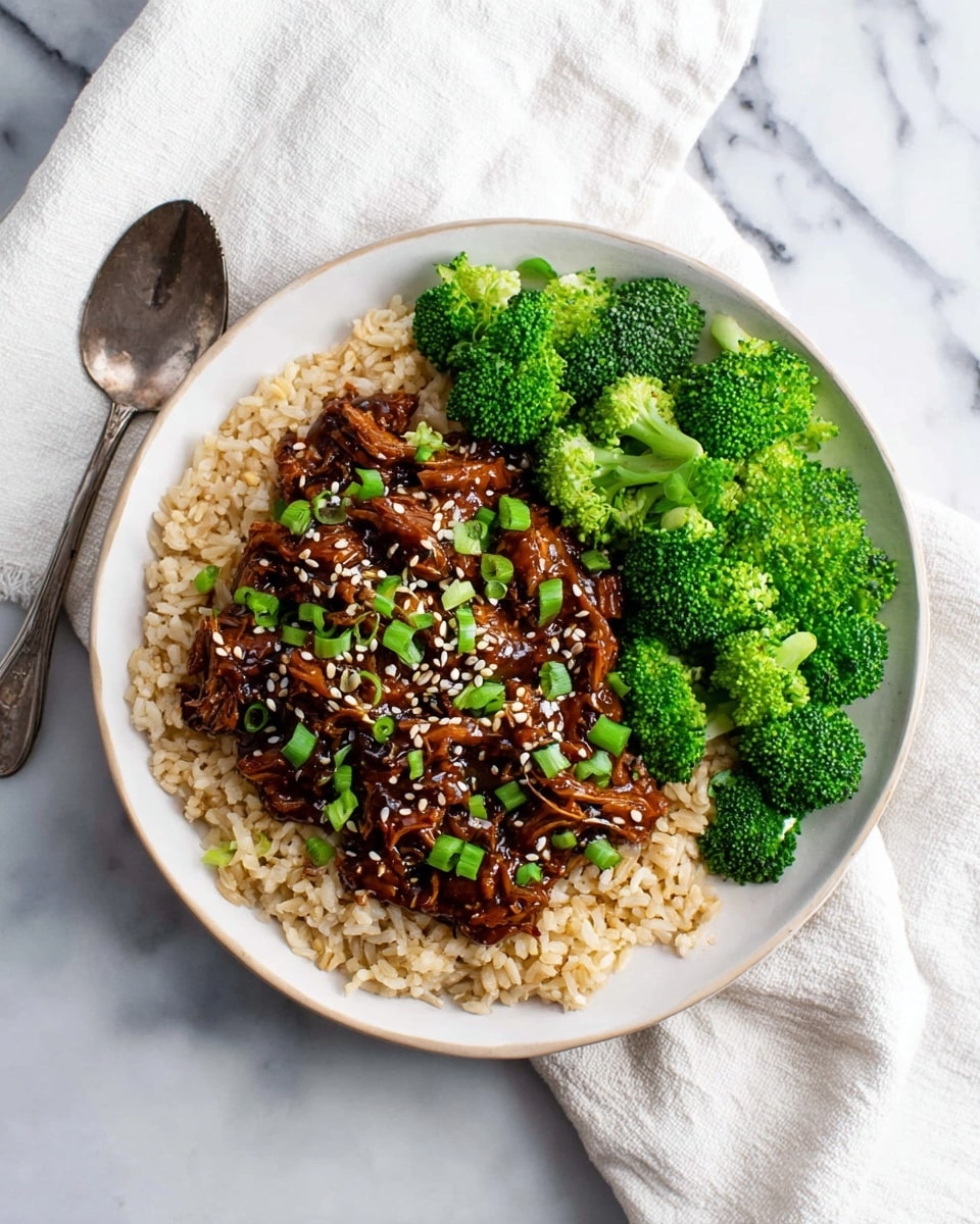 A white plate filled with three main layers: the bottom layer is a soft bed of light brown rice spread evenly, the middle layer is a thick portion of dark brown shredded meat covered in a shiny sauce, and the top layer is sprinkled with bright green sliced scallions and small white sesame seeds, arranged mainly on the meat. On one side of the plate, vibrant green broccoli florets are placed in a neat cluster, contrasting with the brown tones. The plate sits on a white marbled surface with a blurred glass bowl of green herbs and a golden fork in the background. Photo taken with an iphone --ar 4:5 --v 7