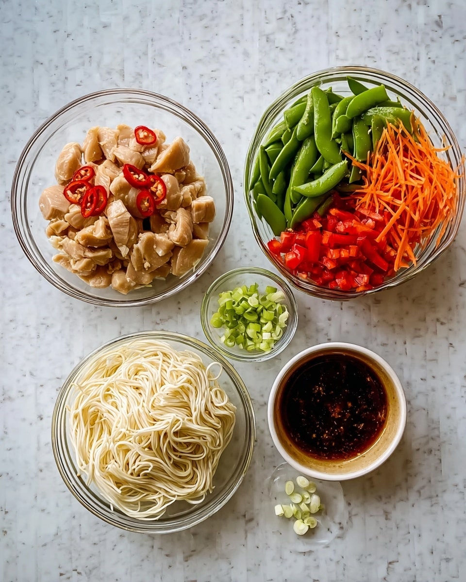 A white marbled surface holds five clear glass bowls with ingredients. The largest bowl on the left contains light brown marinated chicken pieces with red chili slices. Next to it, a bowl is filled with white cooked noodles twisted softly. Above this is a tall bowl layered with bright green snow peas, orange shredded carrots, and coarsely chopped red bell peppers arranged vertically. Below this is a small bowl with finely chopped light green and white scallions. To the right of that is another bowl holding a dark brown sauce with a glossy texture. The arrangement is neat and colorful. Photo taken with an iphone --ar 4:5 --v 7