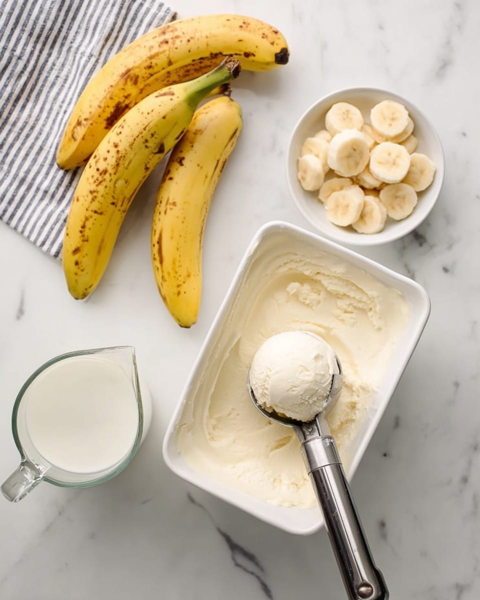 The image shows a white rectangular container filled with creamy white ice cream, with a metal ice cream scoop resting on top, holding a rounded scoop of ice cream. To the left, there are three ripe yellow bananas with brown spots, a small white bowl containing four banana slices arranged in a circle, and a clear glass measuring cup filled with milk. All items are set on a white marbled surface, and a striped cloth is visible in the top left corner. photo taken with an iphone --ar 4:5 --v 7