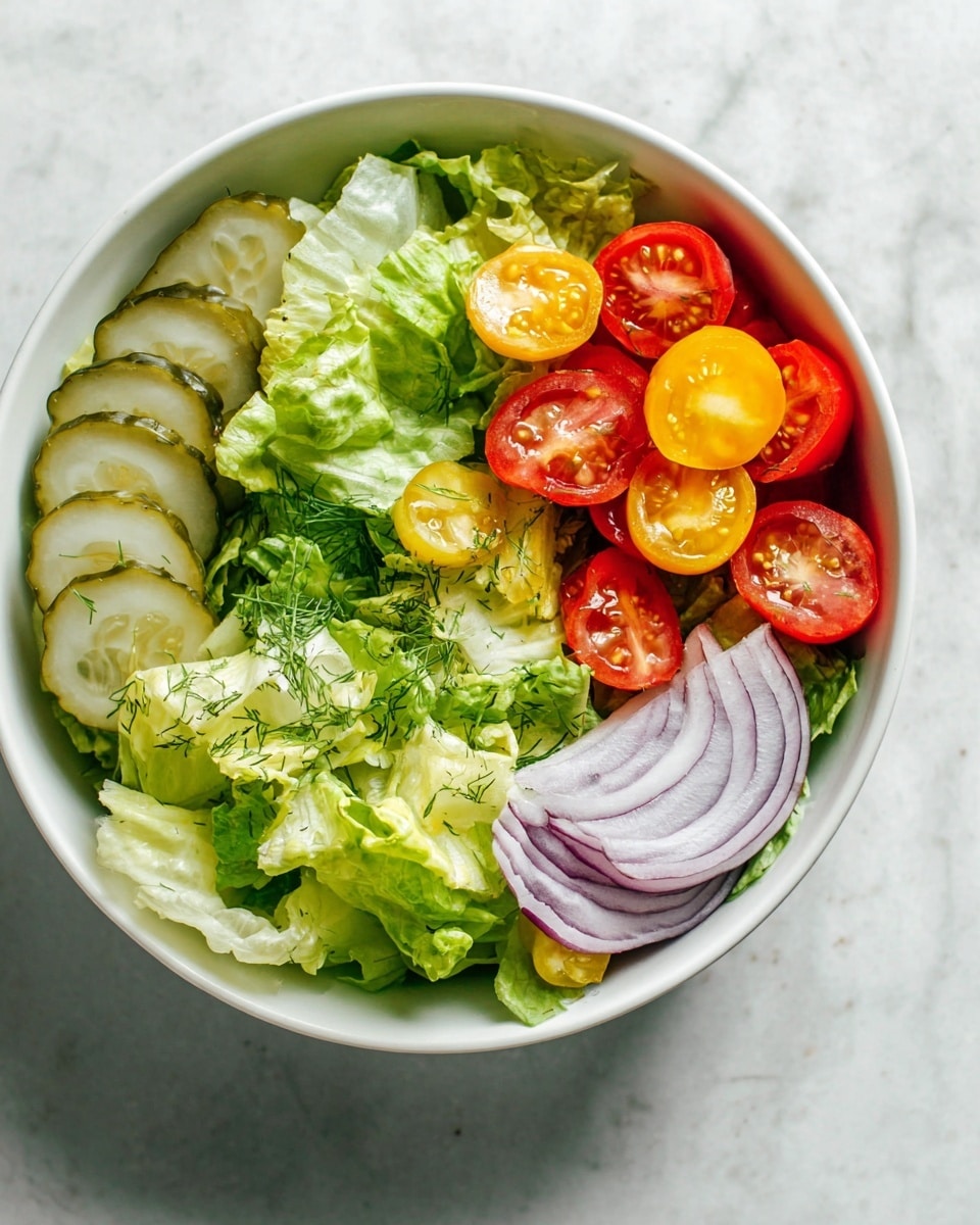 A white bowl filled with fresh salad is placed on a white marbled surface. The salad has four main layers: at the bottom, green lettuce leaves with a mix of light and dark green colors and a crisp texture cover most of the bowl. On the left side, there are five light green, wavy pickle slices stacked slightly on top of the lettuce. On the right side, bright red and yellow cherry tomatoes are halved, showing their juicy, shiny inside with small seeds, sprinkled lightly with fresh green dill. At the bottom right, a small pile of thin, round, translucent purple onion rings rests on the lettuce. The overall look is fresh, colorful, and neatly arranged. photo taken with an iphone --ar 4:5 --v 7