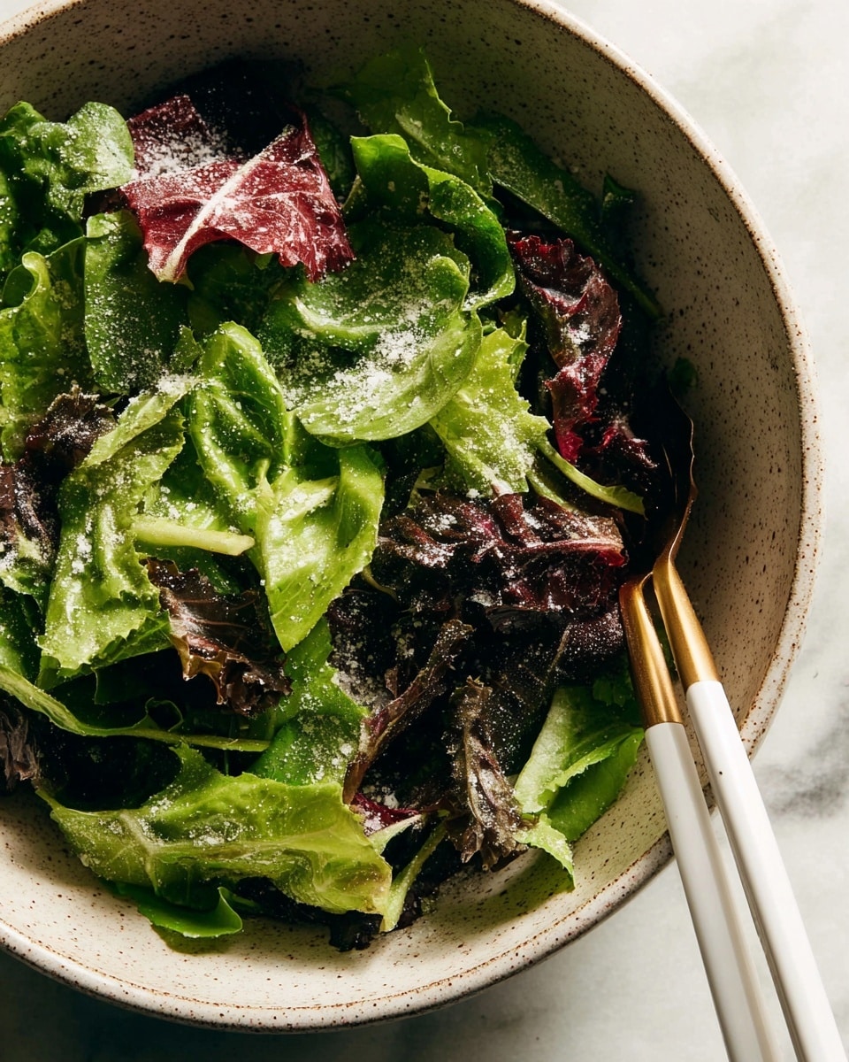 A close-up image shows a large rustic bowl filled with fresh mixed green leafy lettuce, some leaves are dark green and others are a reddish-purple. A woman's hand is holding a clear jar, pouring a thick, brown dressing over the lettuce. The bowl is textured with a greyish tone and sits on a white marbled surface. In the background, out of focus, there is a clear container with some more greens. The lighting is natural and soft, highlighting the fresh greens and the glossy texture of the dressing being poured. Photo taken with an iphone --ar 4:5 --v 7