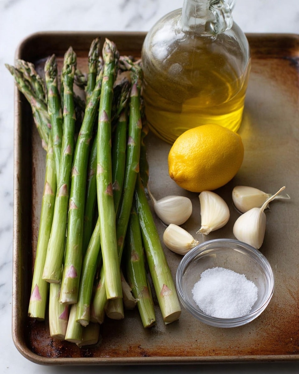 A baking tray holds a small bunch of fresh green asparagus spears grouped on the left side, with firm tips and thick stalks showing light purple hues near the ends. To the right of the asparagus are three peeled garlic cloves with smooth, off-white surfaces, placed near a bright yellow lemon with a slightly rough texture. Behind these ingredients, a glass bottle with a round body and a short neck contains golden olive oil. To the far right, a clear glass small bowl holds white granulated salt. The tray rests on a white marbled surface. Photo taken with an iphone --ar 4:5 --v 7