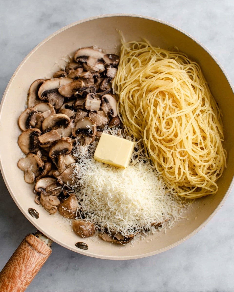 In a cream-colored frying pan with a wooden handle, there are three main layers visible. On the left side, there is a layer of sliced brown mushrooms with a slightly glossy texture. On the right side, there is a neat pile of cooked yellow spaghetti pasta with a smooth texture. In the middle, there is a mound of finely grated white cheese. On top of the cheese, near the bottom center of the pan, is a small block of pale yellow butter. The pan is placed on a white marbled surface. Photo taken with an iphone --ar 4:5 --v 7