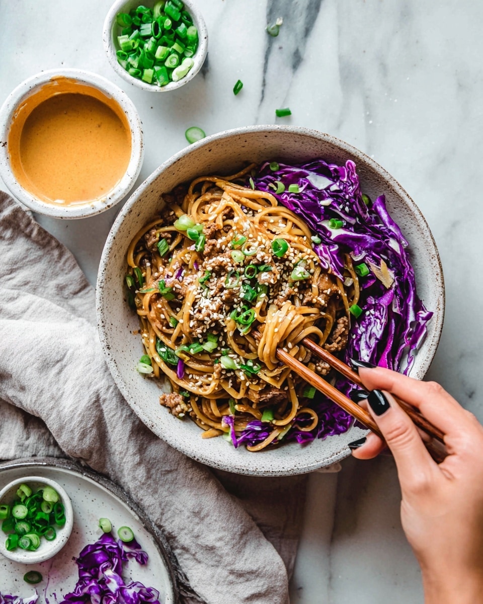 A white speckled bowl holds layered brown noodles mixed with small pieces of light brown meat, topped with chopped green onions and white sesame seeds scattered across. On the right side, vibrant purple cabbage adds a colorful contrast. A woman's hand with dark nail polish is holding wooden chopsticks, lifting some cabbage from the bowl. Nearby, three small white bowls contain extra chopped green onions, purple cabbage, and a creamy orange sauce. The scene is set on a white marbled surface with a light gray cloth nearby. Photo taken with an iphone --ar 4:5 --v 7