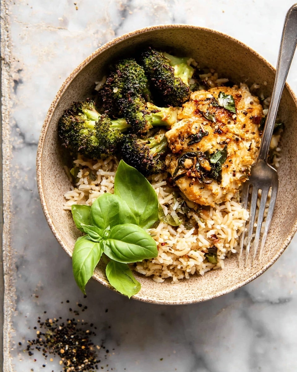 A bowl filled with three main layers: the bottom layer is cooked rice mixed with herbs and small spices, colored light brown and white with a fluffy texture, a middle layer showing a piece of golden-brown grilled chicken topped with small bits of herbs and spices, and the top layer consisting of three small pieces of roasted broccoli, dark green with charred edges, along with fresh bright green basil leaves on one side. A silver fork rests on the right side inside the bowl, and the bowl itself is set on a white marbled textured surface with scattered black pepper around it. Photo taken with an iphone --ar 4:5 --v 7