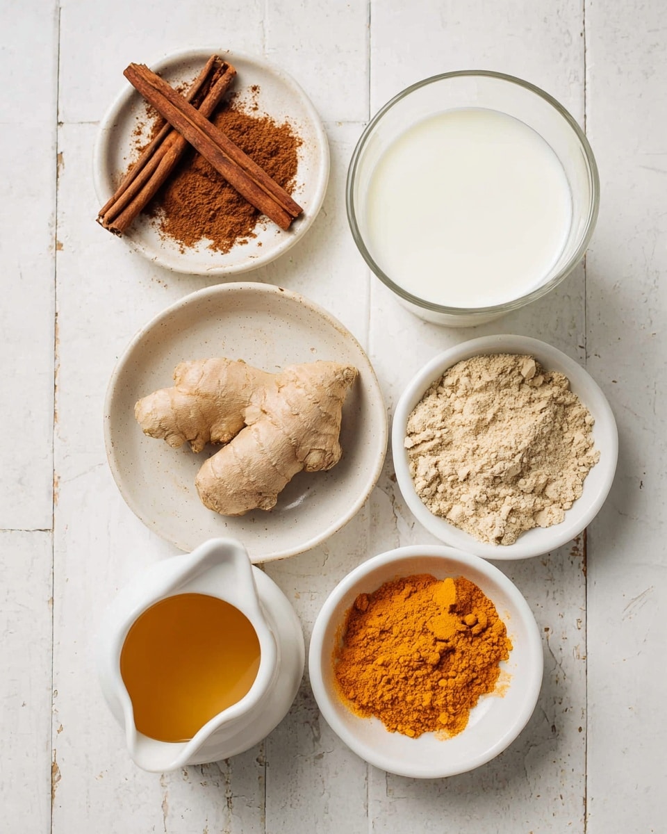 Five white dishes with different ingredients are arranged on a white marbled tiled surface. At the top left, a small bowl holds three brown cinnamon sticks lying on a pile of ground cinnamon powder, showing rough texture and deep warm brown color. To the right is a clear glass cup filled with smooth, white milk. Below the cinnamon, a white bowl contains a piece of light brown ginger root resting on a heap of beige ground ginger powder, both showing rough and grainy textures. To the right, another white bowl holds bright orange turmeric powder with a fine texture and some small clumps. At the bottom left is a small white pitcher filled with golden brown honey, showing a shiny and liquid surface. The scene is well lit, with soft shadows, photo taken with an iphone --ar 4:5 --v 7