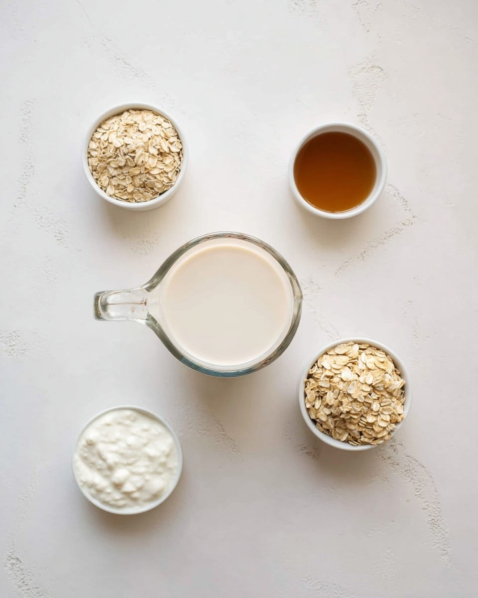 The image shows a top view of a white marbled surface with four ingredients spaced evenly around a central glass measuring cup filled with creamy white liquid. To the top right is a small white bowl filled with brown liquid. To the top left is a small white measuring cup with light beige dry oats. At the bottom right is a white measuring cup filled with dry light brown oats, and at the bottom left is a small white bowl with thick white yogurt. The items are arranged neatly with clear space between them, and the lighting is soft and natural. Photo taken with an iphone --ar 4:5 --v 7