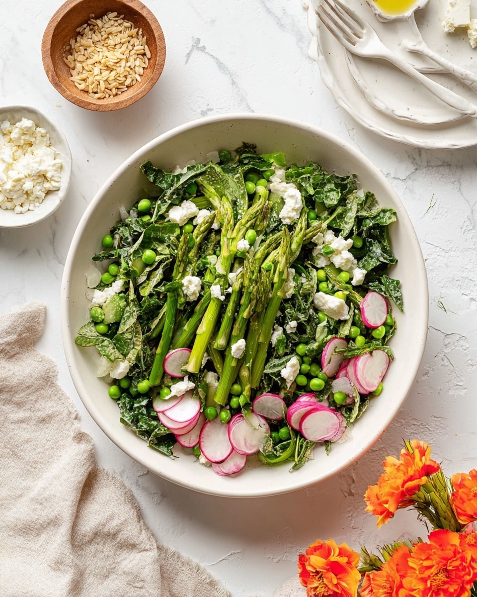 A white bowl filled with a fresh green salad showing three main layers: the bottom layer has bright green asparagus slices cut diagonally, the middle layer includes sliced radishes with white and pink colors, and the top layer is made of green leafy kale and small green peas scattered across, with small dollops of soft white cheese mixed in. The salad is placed on a white marbled surface, with a white bowl of crushed nuts or seeds on the upper left, a wooden bowl with coarse salt on the lower right, and beige cloth under the bowl. On the top right, there is a white salad spoon and fork resting on a white plate with bright orange flowers beside it. Photo taken with an iphone --ar 4:5 --v 7