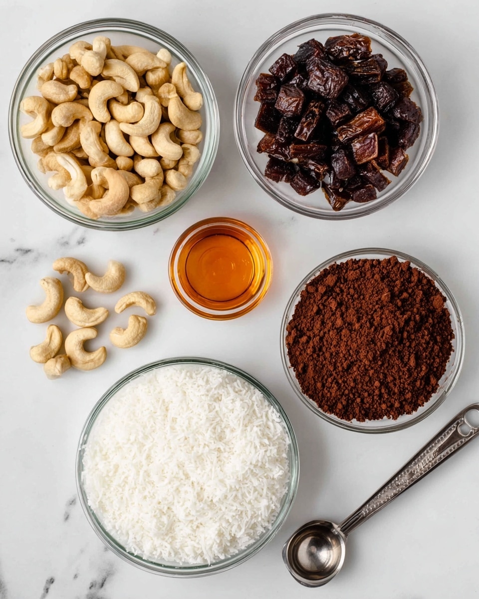 A white marbled surface holds five clear glass bowls arranged loosely in a circular pattern. The top left bowl is filled with light brown cashews showing a smooth, slightly curved texture. To the right, a smaller bowl contains dark brown chopped dates with a shiny, sticky look. Below that, a medium bowl is filled with dark brown cocoa powder, its fine, crumbly texture spreading evenly across the bowl. On the bottom left, another bowl is full of white shredded coconut with a soft, fluffy texture. A tiny bowl near the center contains amber-colored vanilla extract, glossy and smooth. To the right of the bowls, a silver metal measuring spoon and a silver metal scoop lie on the white marbled surface. Photo taken with an iphone --ar 4:5 --v 7