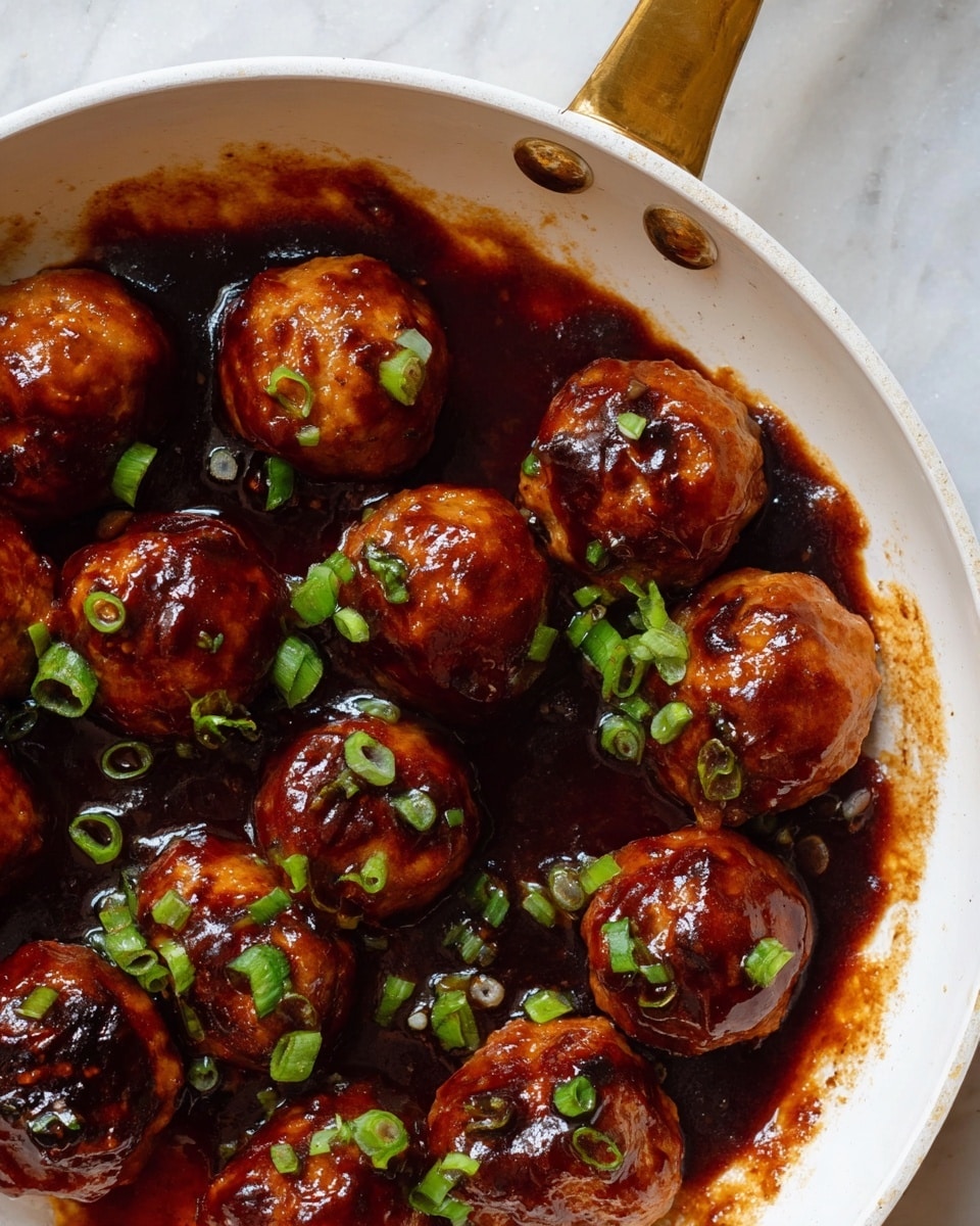 A white pan with a golden handle holds several small browned meatballs covered in thick dark reddish-brown sauce. The sauce spreads unevenly, creating shiny pools and streaks around and under the meatballs. Freshly chopped green onions are scattered on top, adding bright green contrast. The background is a white marbled surface. photo taken with an iphone --ar 4:5 --v 7
