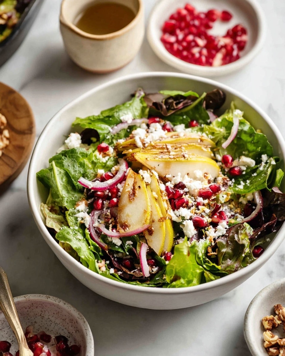A white bowl filled with a fresh salad sits on a white marbled surface. The salad has three main layers: the bottom layer is mixed dark and bright green leafy greens; the middle layer features light yellow pear slices and thin purple onion strips; the top layer is sprinkled with white crumbled cheese, bright red pomegranate seeds, and small crushed nuts. Around the bowl, there are small white dishes with pomegranate seeds and nuts, along with a small light beige cup. photo taken with an iphone --ar 4:5 --v 7