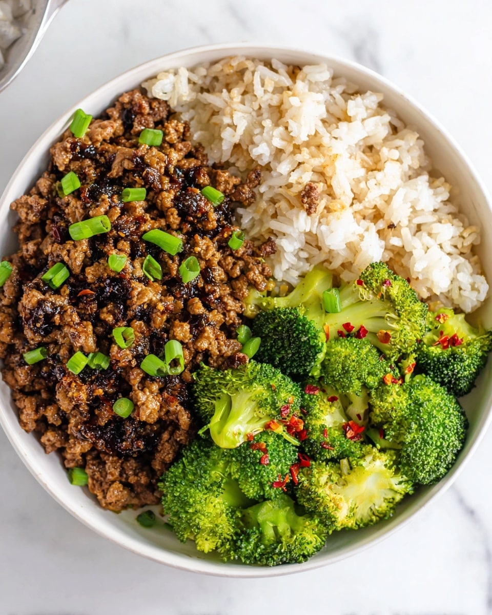 A white bowl holds three layers of food: on the left side there is cooked broccoli with a bright green color and some red pepper flakes sprinkled on top, next to it on the right is a mound of white rice with a few grains of brown rice mixed in, and above the broccoli and rice is a pile of cooked minced meat covered in a dark brown sauce with small chopped green onions scattered on top. The bowl is set on a white marbled surface. photo taken with an iphone --ar 4:5 --v 7