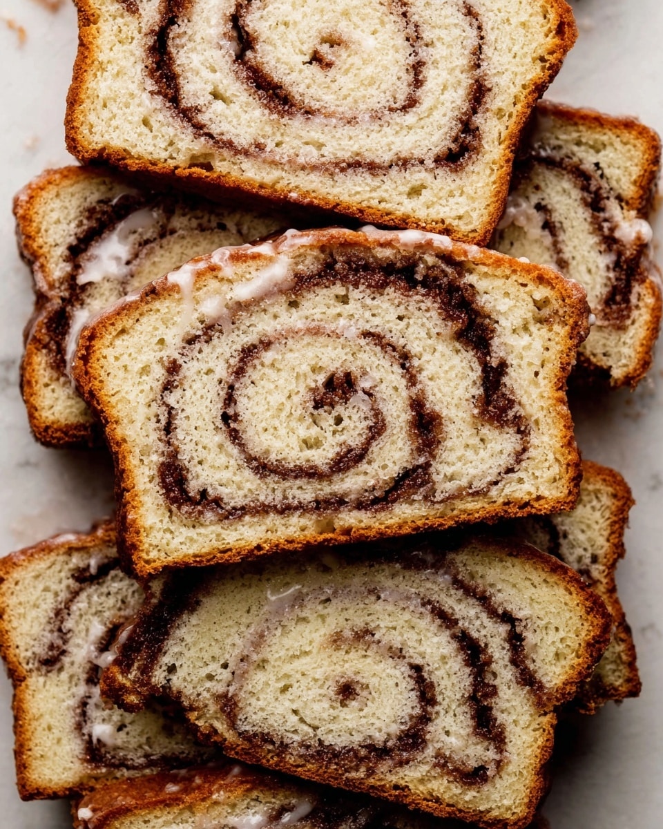 The image shows multiple slices of cinnamon swirl bread arranged closely together on a white marbled surface. Each slice has one main layer of soft, light golden-brown bread with a moist texture, swirled with dark brown cinnamon sugar filling that creates a spiral pattern inside. The edges of the bread are lightly browned and crisp. A thin layer of white glaze lightly coats the top edges of some slices, adding a shiny and slightly sticky texture. The overall presentation clearly highlights the contrast between the light bread and the dark cinnamon swirls. photo taken with an iphone --ar 4:5 --v 7