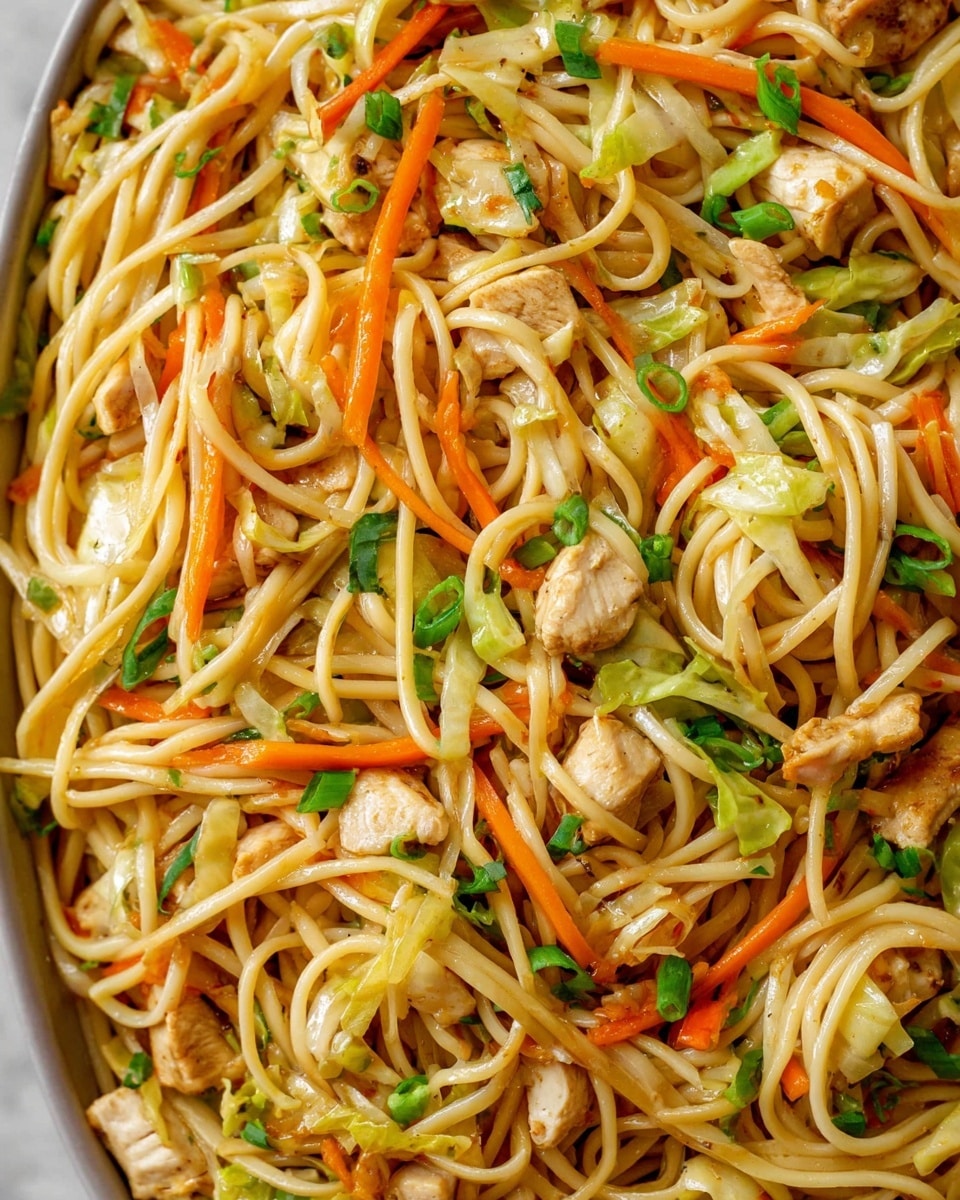 A close-up view of a dish made of long, thin noodles mixed with small, light brown pieces of chicken, thin orange carrot strips, and pale green cabbage pieces. Scattered throughout are small green onion slices adding a fresh touch. The noodles are slightly glossy, twisting and weaving through the colorful vegetables and chicken, creating a textured and vibrant mix. The whole dish is set against a white marbled surface. photo taken with an iphone --ar 4:5 --v 7