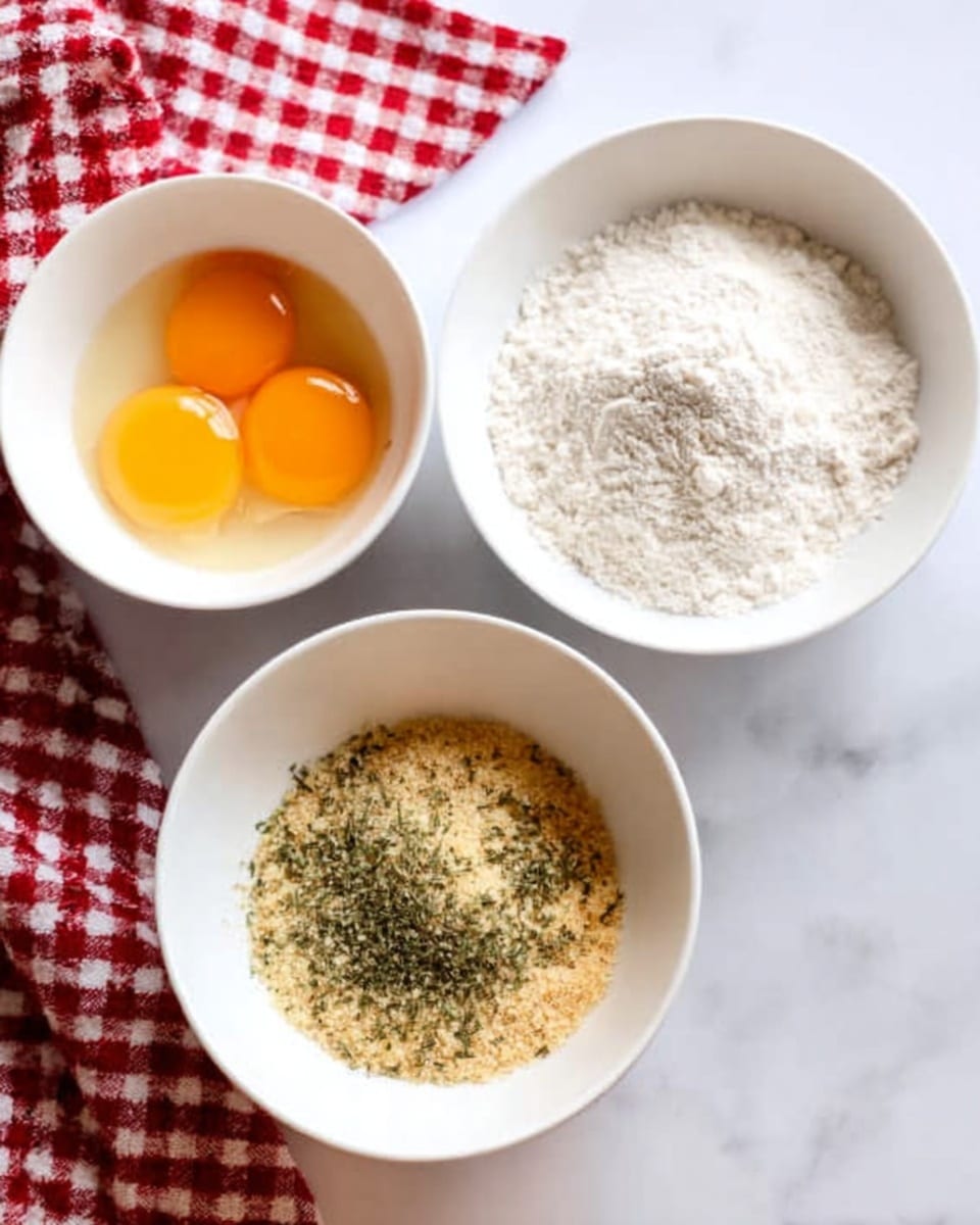 The image shows three white bowls placed on a white marbled surface with a red and white checkered cloth in the background. The bowl on the top left contains two raw eggs with bright yellow yolks and clear egg whites. The bowl on the top right holds white flour with a soft, powdery texture. The bowl at the bottom contains light golden breadcrumbs mixed with green dried herbs sprinkled on the top. A woman's hand is gently resting near the bowls. Photo taken with an iphone --ar 4:5 --v 7